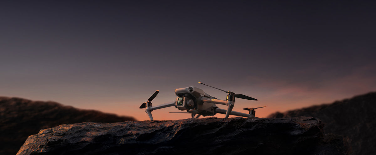 A DJI Mavic 3 Cine on a rock ledge at dusk